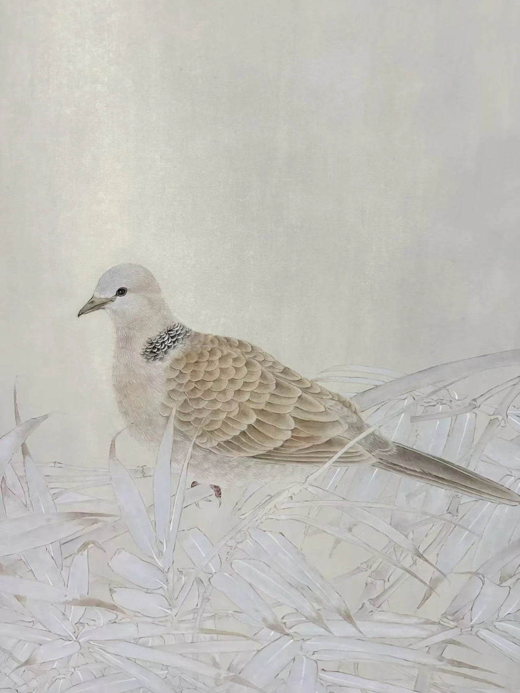 A fine art painting of a pale beige and gray bird with a speckled dark neck, standing amidst delicate white leaves against a textured cream background.