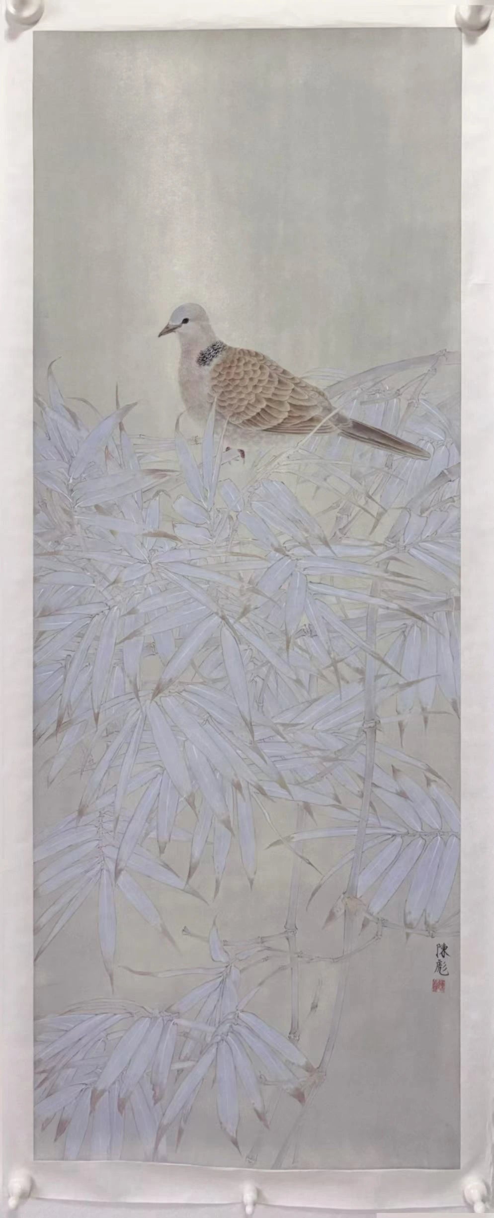 A traditional Chinese-style vertical painting depicting a small dove perched among delicate white bamboo leaves on a pale gray background.